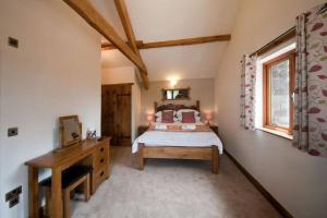 a bedroom with a bed and a desk and a window at Oak Barn in Brecon
