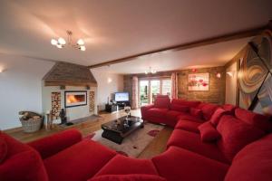 a living room with a red couch and a fireplace at Oak Barn in Brecon