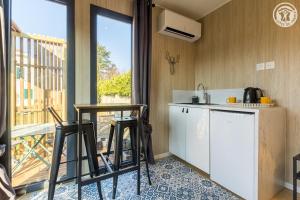 a kitchen with a table and chairs and a balcony at La cabane du pecheur in Aix-les-Bains