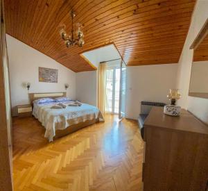 1 dormitorio con cama y techo de madera en Apartments Malvina, en Rovinj