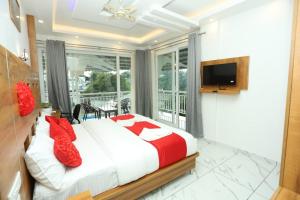 - une chambre avec un lit doté d'oreillers rouges et une télévision dans l'établissement Cloud bed holidays, à Munnar