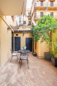 un patio con 2 sillas y una mesa frente a un edificio en Il Giardino del Colosseo, en Roma