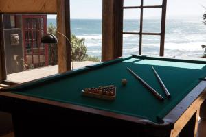 una mesa de billar con dos bolas y palillos. en Casa Santa Mar, en la mejor ubicación de Pichilemu, en Pichilemu
