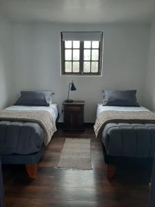 1 dormitorio con 2 camas y ventana en Casa Santa Mar, en la mejor ubicación de Pichilemu en Pichilemu