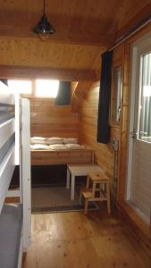 Cabaña pequeña con cama y taburete. en Boothuis Lauwersoog en Lauwersoog