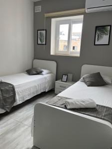 - une chambre avec 2 lits et une fenêtre dans l'établissement F3 Room 3, Private Room two single beds shared bathroom, à Msida