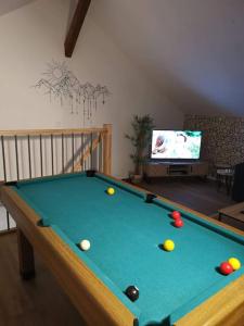 a living room with a pool table and a tv at T4 La Bresse 6 a 8 couchages in La Bresse