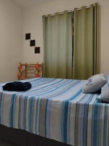 sypialnia z łóżkiem z niebiesko-białym kocem w obiekcie Casa de praia em Unamar com piscina w mieście Cabo Frio
