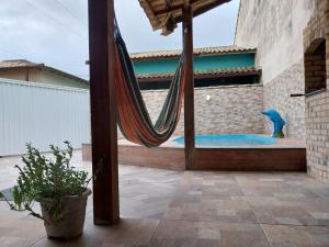 卡波布里奧的住宿－Casa de praia em Unamar com piscina，庭院内的吊床,设有游泳池