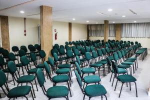 a room filled with green chairs in a room at ARAGUAIA HOTEL in Barra do Garças