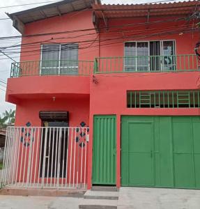 a red and green house with green garage doors at Casa da Deusa in Belém