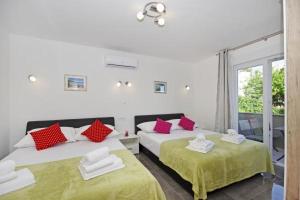 a bedroom with two beds with red and white pillows at Apartment Blue Eyes in Podstrana