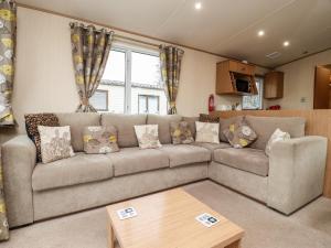 a living room with a couch and a table at 12 Broughton Park - Sanctuary in Morecambe