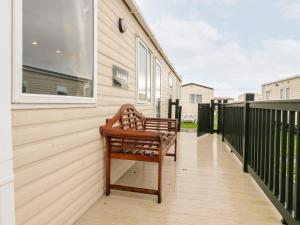 a wooden bench sitting on the balcony of a house at 12 Broughton Park - Sanctuary in Morecambe