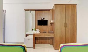 a room with two beds and a desk with a television at Hotel Prime Pavilion-MG ROAD in Bangalore