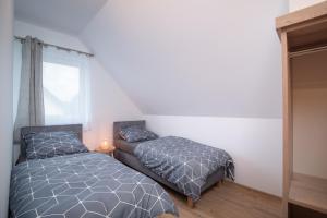 Un dormitorio con dos camas y una ventana. en Hamak Lubiatowo, en Lubiatowo