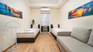 un soggiorno con divano e letto di Palmy Home Dunakeszi a Dunakeszi