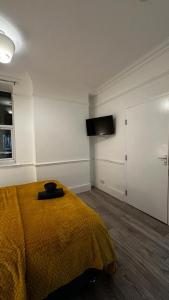 a bedroom with a bed and a flat screen tv at Wandsworth Guest Studio 64 in London