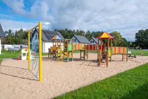 a playground with colorful playground equipment in the sand at Hamak Lubiatowo in Lubiatowo