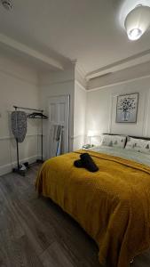 a bedroom with a large bed with a yellow blanket at Wandsworth Guest Studio 64 in London