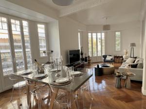 ein Wohnzimmer mit einem Tisch und Stühlen in der Unterkunft Luxueux appartement climatisé 3 chambres avec parking carré d'or in Nizza