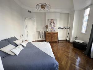 1 dormitorio con 1 cama azul y suelo de madera en Luxueux appartement climatisé 3 chambres avec parking carré d'or, en Niza
