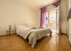 1 dormitorio con cama y ventana grande en Apartments Malvina, en Rovinj