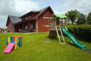 een speeltuin met een glijbaan in de tuin van een huis bij Poplar Tree Eco Lodge in Brecon