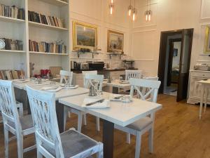 une salle à manger avec des tables et des chaises blanches dans l'établissement Villa Campana, à Siófok