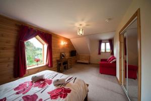 een slaapkamer met een bed en een rode bank bij Poplar Tree Eco Lodge in Brecon