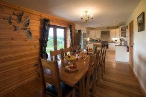 cocina y comedor con mesa y sillas en Poplar Tree Eco Lodge en Brecon