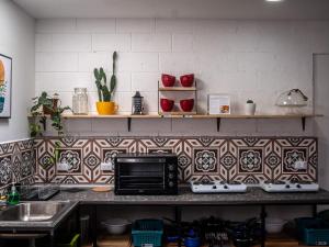 cocina con encimera y microondas en Lolas Hostal, Habitacion Exclusiva para Mujeres, 2 camarotes, precio por cama, en San José