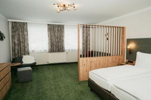 a bedroom with a bed and a desk and a chair at Apparthotel Samson in Obertauern