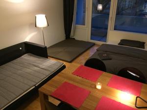 Habitación con 2 camas, mesa y ventana en Apartment Schwabing/Olympic Park/BMW en Múnich