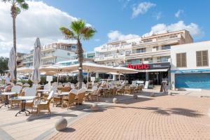 un patio avec des tables et des chaises et un bâtiment dans l'établissement Antic 201, à S'illot