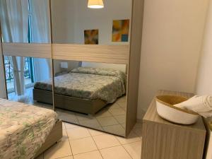 1 Schlafzimmer mit 2 Betten und einem Spiegel in der Unterkunft Una finestra sul mare in Savona