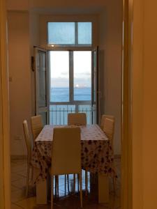 einen Esstisch mit Stühlen und Meerblick in der Unterkunft Una finestra sul mare in Savona