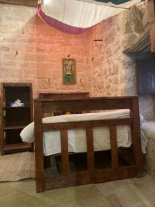 a bedroom with a wooden bunk bed in a brick wall at نزل كوفان التراثي Koofan Heritage Lodge in Salalah