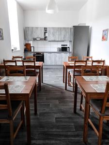 a classroom with wooden tables and chairs and a kitchen at Apartmány u Maxíků in Horní Maršov