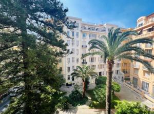 un gran edificio con palmeras delante en Luxueux appartement climatisé 3 chambres avec parking carré d'or, en Niza