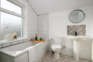 a bathroom with a tub and a sink and a toilet at Asher Suite by Koya Homes in Barry