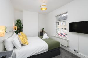 a bedroom with a bed and a flat screen tv at Asher Suite by Koya Homes in Barry
