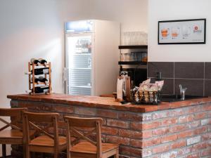 a kitchen with a brick counter with chairs at Apartmány u Maxíků in Horní Maršov