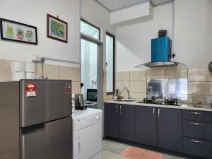 a kitchen with a refrigerator and a sink at Relax Bear Homestay in Tanah Rata