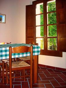 comedor con mesa, sillas y ventana en Il Borrino en Gavinana