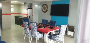 uma sala de jantar com uma mesa vermelha e cadeiras azuis em 1403 on 10 South Beach em Durban