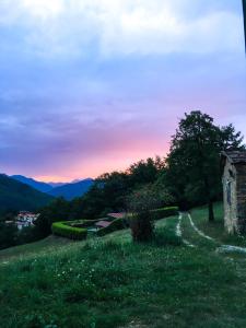 einen Weg auf einem Hügel mit Sonnenuntergang im Hintergrund in der Unterkunft Il Borrino in Gavinana