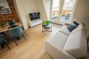 ein Wohnzimmer mit einem Sofa und einem Tisch in der Unterkunft Spectacular 70m2 Penthouse with Terrace in Eindhoven