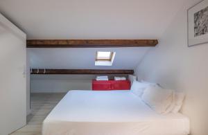 Schlafzimmer mit einem weißen Bett und einer roten Box in der Unterkunft Résidence Clignancourt in Paris