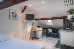 Un dormitorio con una cama, un televisor y un sofá. en Résidence Clignancourt, en París